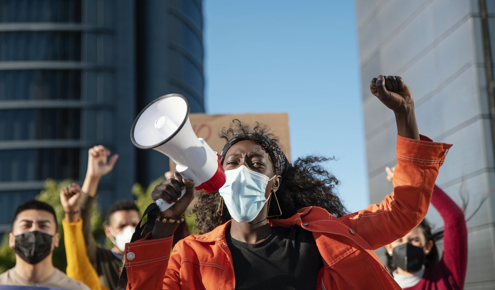 close up woman with megaphone wearing mask