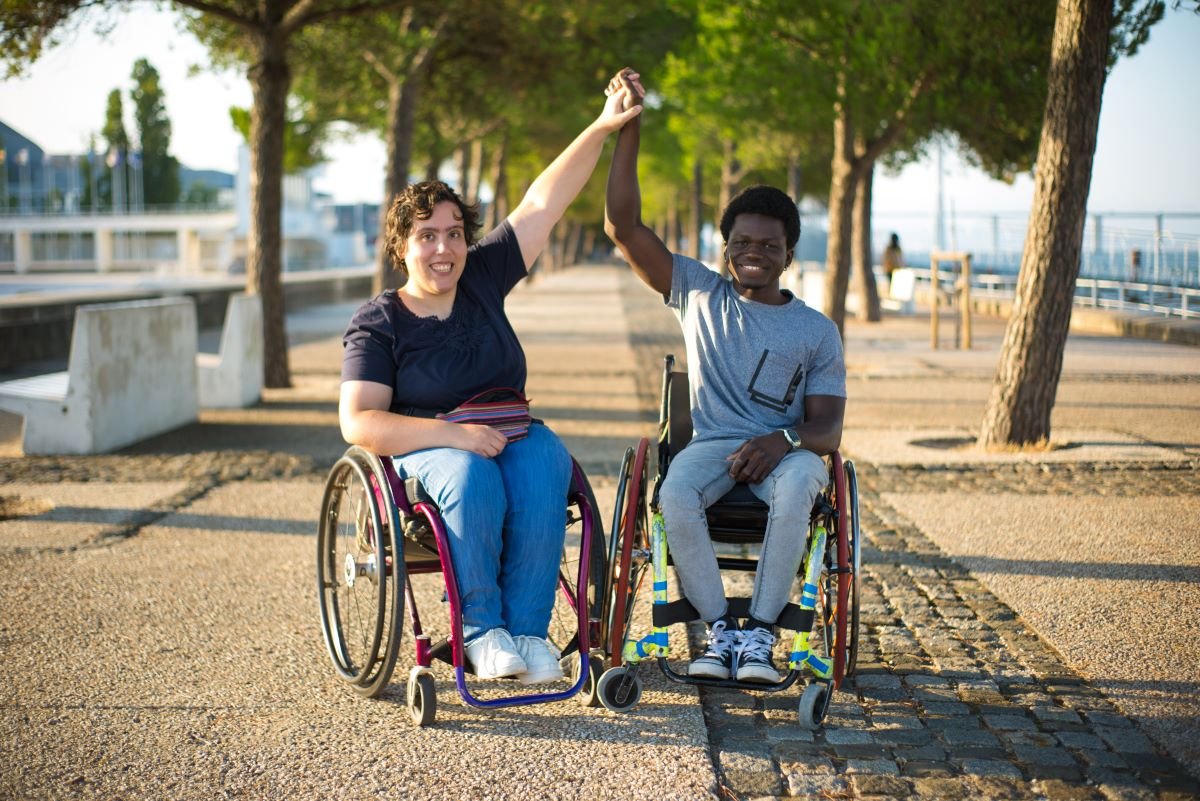portrait biracial family romantic date park african american man caucasian woman wheelchairs holding hands smiling love relationship happiness concept