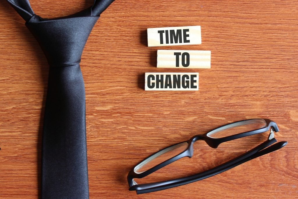 top view black necktie black glasses wooden tiles with text time change