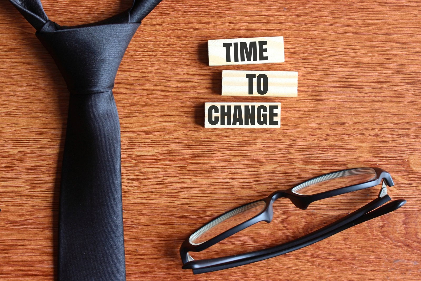 top view black necktie black glasses wooden tiles with text time change